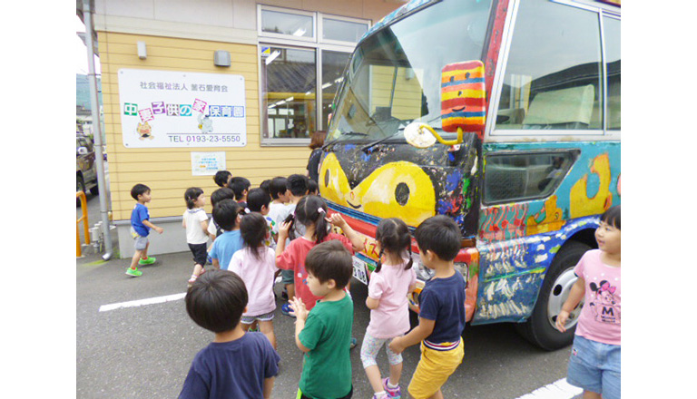 笑顔バスを子供たちが出迎えている